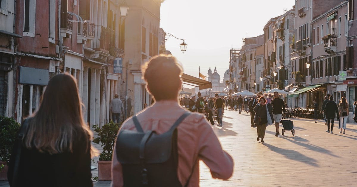 People strolling through a picturesque street in Venice at sunset